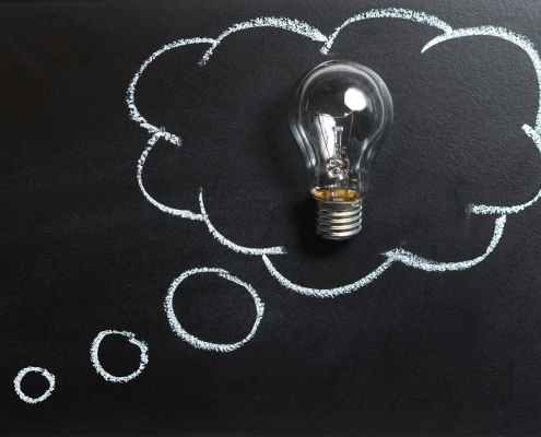 clear light bulb placed on chalkboard