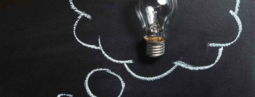 clear light bulb placed on chalkboard