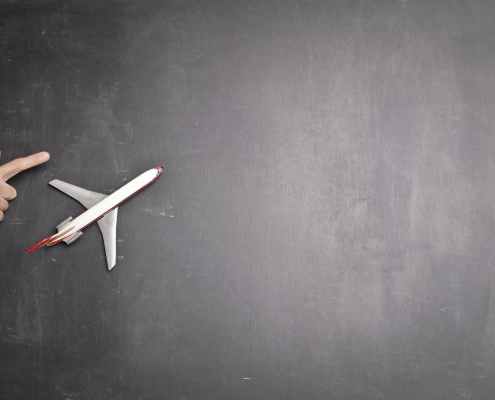 toy plane and human hand on chalkboard